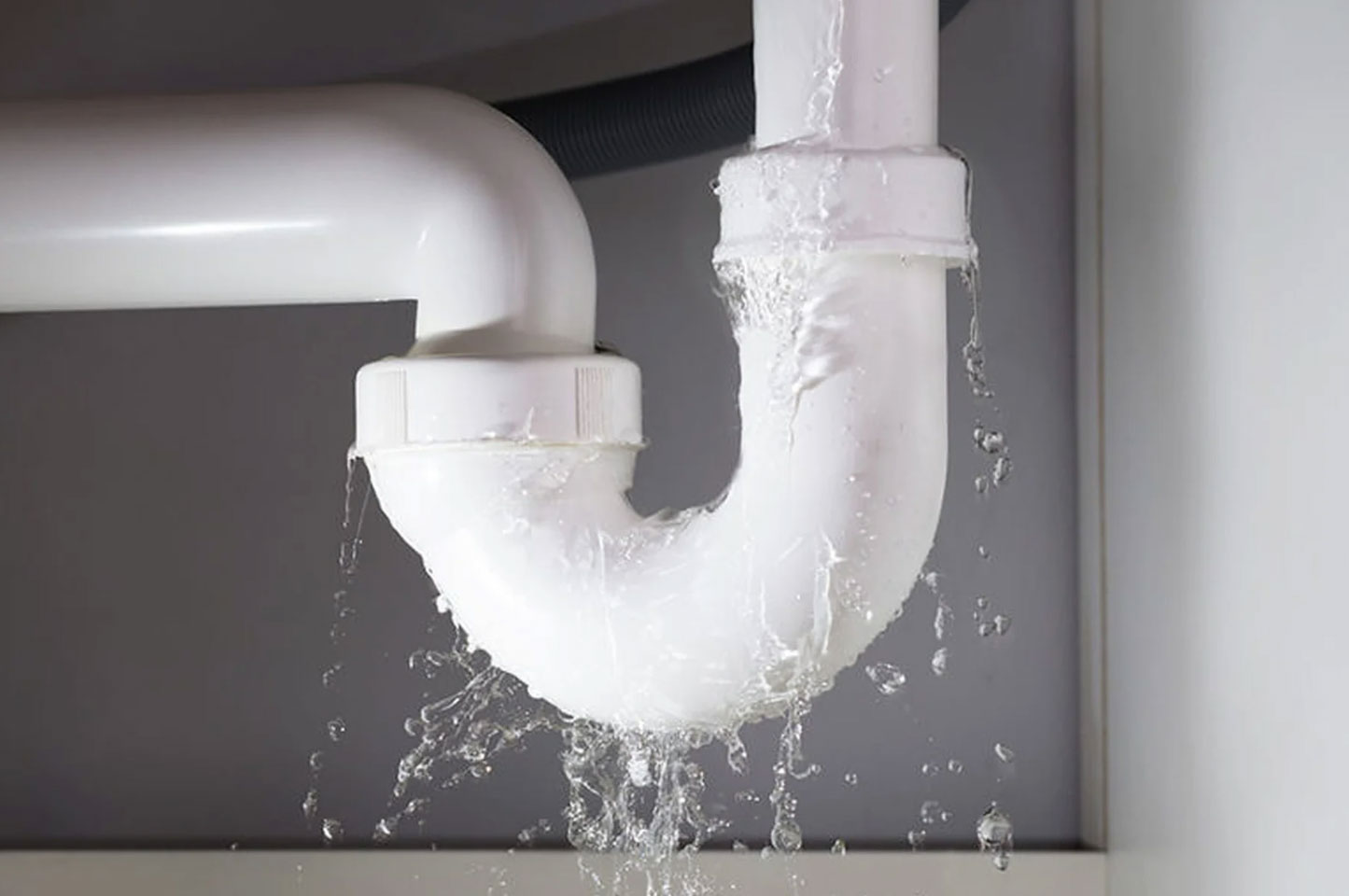 A pipe that is leaking causing a lot of water flowing out of the pipe and water damage in the house