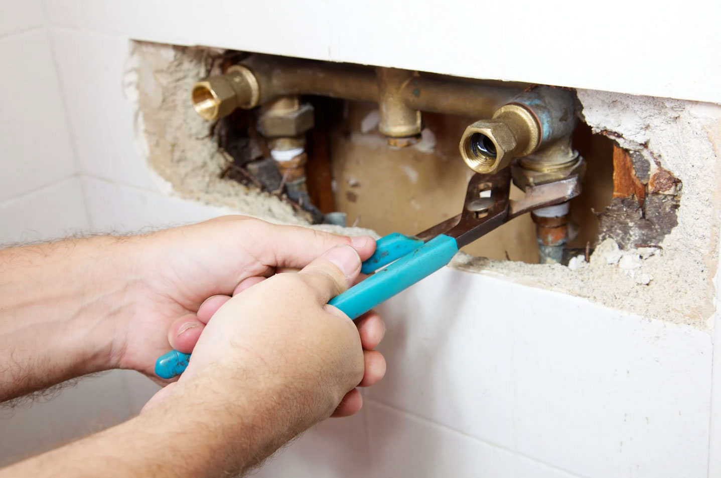 a plumber fixing a dealing pipe that has been causing water damage from the plumbing issue
